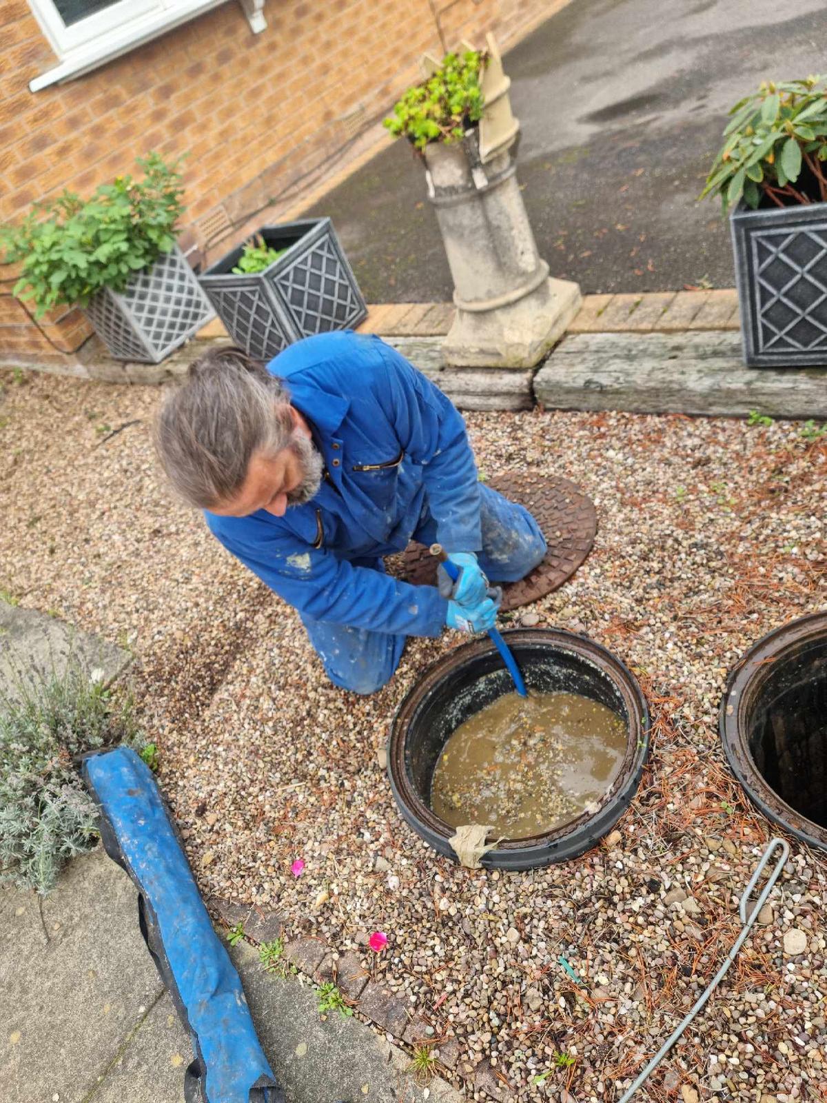 A drain engineer performing emergence unblocking on a unmaintained drain.
