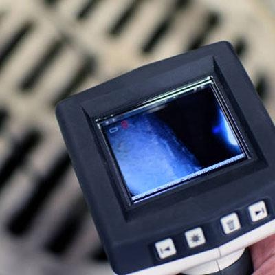 A Budget Drain Nottingham engineer checking CCTV footage of a blocked toilet and soil stack