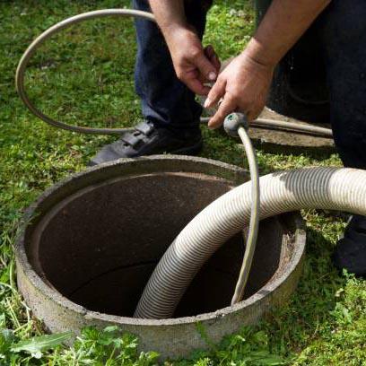 A photo of a Budget Drains Nottingham engineer using a high pressure water jetter to unblock a drain