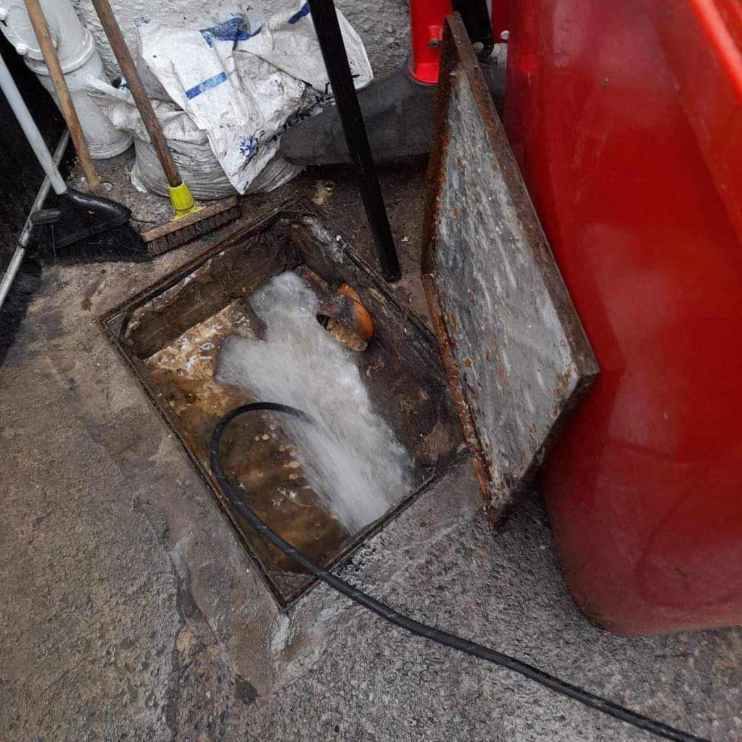 Professional drainage engineer using high-pressure equipment to unblock a residential drain in Nottingham