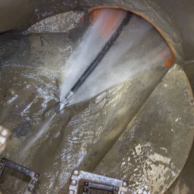 Drain jetter in use clearing a blocked sewer line